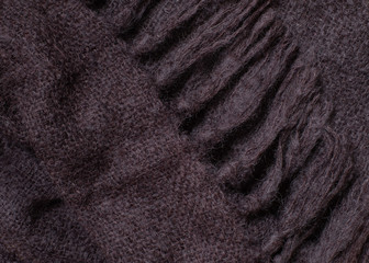 Fototapeta na wymiar Vintage knitted wool scarf with brown fringe, close-up