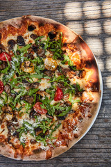 Italian pizza with truffle, rocket, cherry tomatoes and italian cheeses