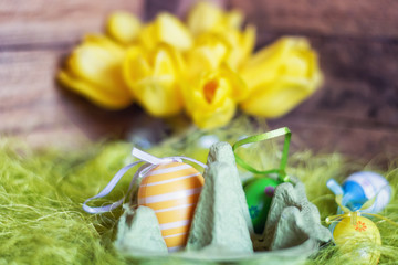 Easter composition with an egg box filled with colorful fake eggs