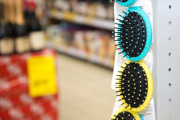 Obraz premium Colored hair brushes are sold. Combs for hair on a stand in a supermarket with copy space