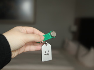 The key is electronic green with a metal tag from the hotel room in hand