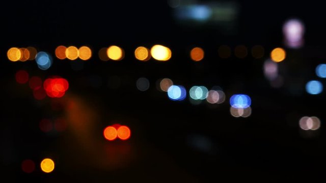 Moving bokeh circles from the lights of cars running on the city streets. City blur background.  Night traffic.
