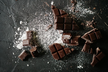 Top view od smashed dessert chocolate with powdered sugar on slate