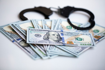 bribe corruption concept- handcuffs and dollars