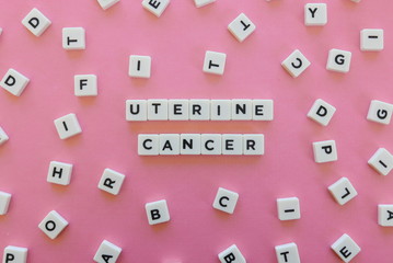 Uterine cancer word made of square letter word on pink background.