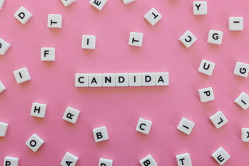 Candida word made of square letter word on pink background.