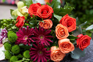 A beautiful bouquet of fresh flowers close-up is on the table. Bouquet of green roses, pink chrysanthemums, anthurium, eucalyptus, phalaenopsis and pistachio greens