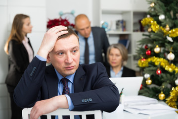 Business team tensely solving problems in office with offended man foreground