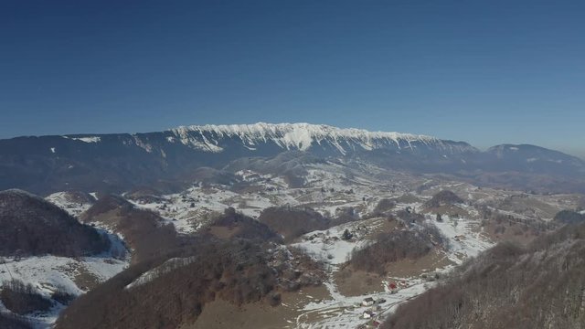 Drone flying towards snowy peaks mountain range