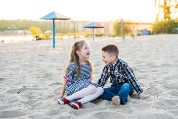 Fototapeta na wymiar children having fun on the beach. boy and girl are lough