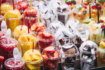 Fototapeta na wymiar Fruits tranchés dans des gobelets en plastique sur un stand au marché de la Boqueria à Barcelone