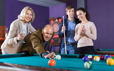 Relaxed people playing billiard and darts as hanging out