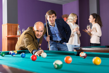 Group of adults playing pool.