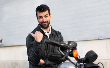 Young man on a motorbike pointing to the lateral