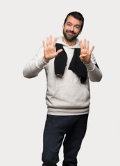 Sport man counting nine with fingers over isolated grey background