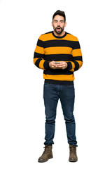 Naklejka premium Full-length shot of Handsome man with striped sweater surprised and sending a message on isolated white background