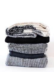 Stack of various sweaters isolated on white background.A stack of knitted sweaters ,the concept of warmth and comfort, hobby , background,closeup