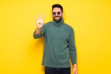 Handsome man with sunglasses happy and counting four with fingers