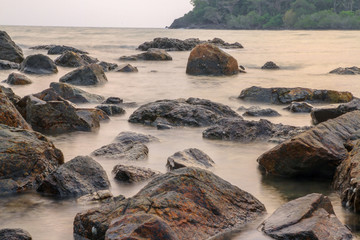 Fototapeta na wymiar smooth sea near rock before sunset