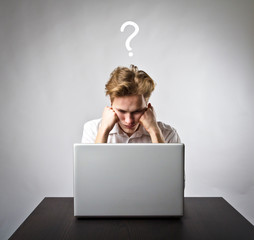 Young man with laptop. Question and ignorance concept.
