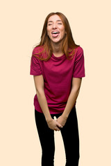 Obraz premium Young redhead girl showing tongue at the camera having funny look on isolated yellow background