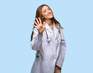 Redhead doctor woman counting five with fingers on isolated blue background