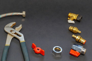 Plumbing accessories and tools on gray background.