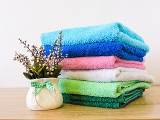 Obraz na płótnie Canvas Stack of colorful bath towels on white background.Pile of rainbow colored towels isolated.Top view.Hygiene, fabric,spa and textile concept.