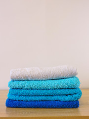 Stack of colorful bath towels  on white background.Pile of rainbow colored towels isolated.Top view.Hygiene, fabric,spa and textile concept.