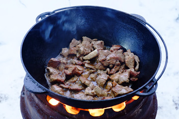 The process of cooking pilaf in a cauldron