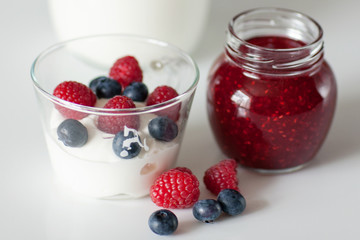 Yogurt with blueberry and raspberry berries in a glass Cup on a white background. Breakfast. Healthy diet.