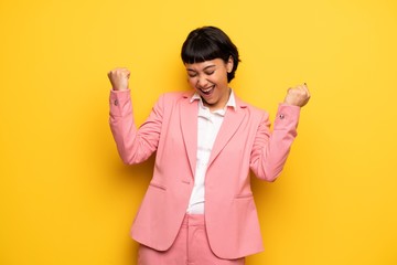 Modern woman with pink business suit celebrating a victory