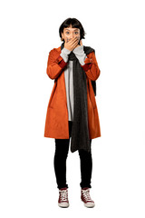 Fototapeta premium A full-length shot of a Short hair woman with coat covering mouth with hands for saying something inappropriate over isolated white background