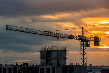 Over view of tower crane in construction machine a sky background, especially in dim light.