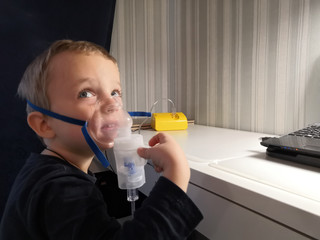 little boy using nebulizer compressor medicine is breathing, is the treatment of diseases of the respiratory tract 