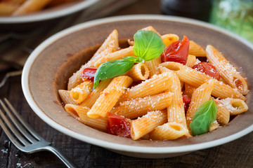 Plate of pasta penne with cherry tomato sauce, fresh basil and grated parmesan cheese - Pasta al...