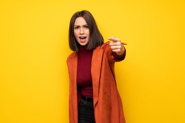 Young woman with coat frustrated and pointing to the front