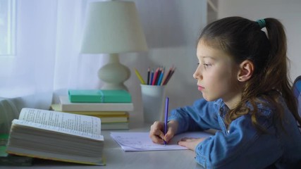 smart little school girl doing homework in mathematics