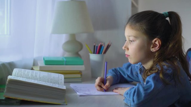 smart little school girl doing homework in mathematics