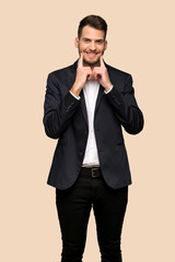 Handsome business man smiling with a happy and pleasant expression over ocher background