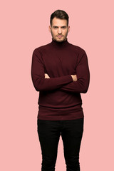 Man with turtleneck sweater portrait over pink background