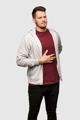 Fototapeta premium Man with sweatshirt suffering from backache for having made an effort over grey background