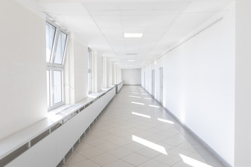 Hospital corridor bright light windows sun rays long white nobody empty