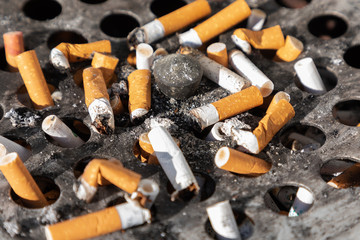 Cigarette ashtray close-up dirty ash ugly round metal 