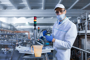 man in a mask and a Bathrobe connects the dosimeter to the dairy Plant