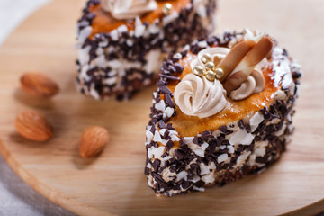 cakes with chocolate chips  and cream decorations  on wooden board on white background.