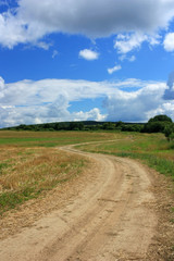 Fototapeta na wymiar Dirt country road in the field