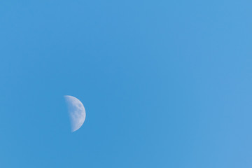 Half moon on a clear blue sky