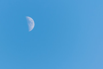 Half moon on a clear blue sky