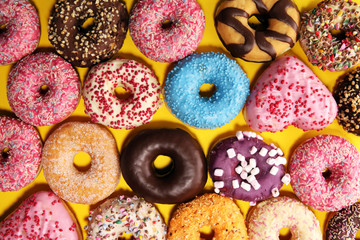 assorted donuts with chocolate frosted, pink glazed and sprinkles donuts